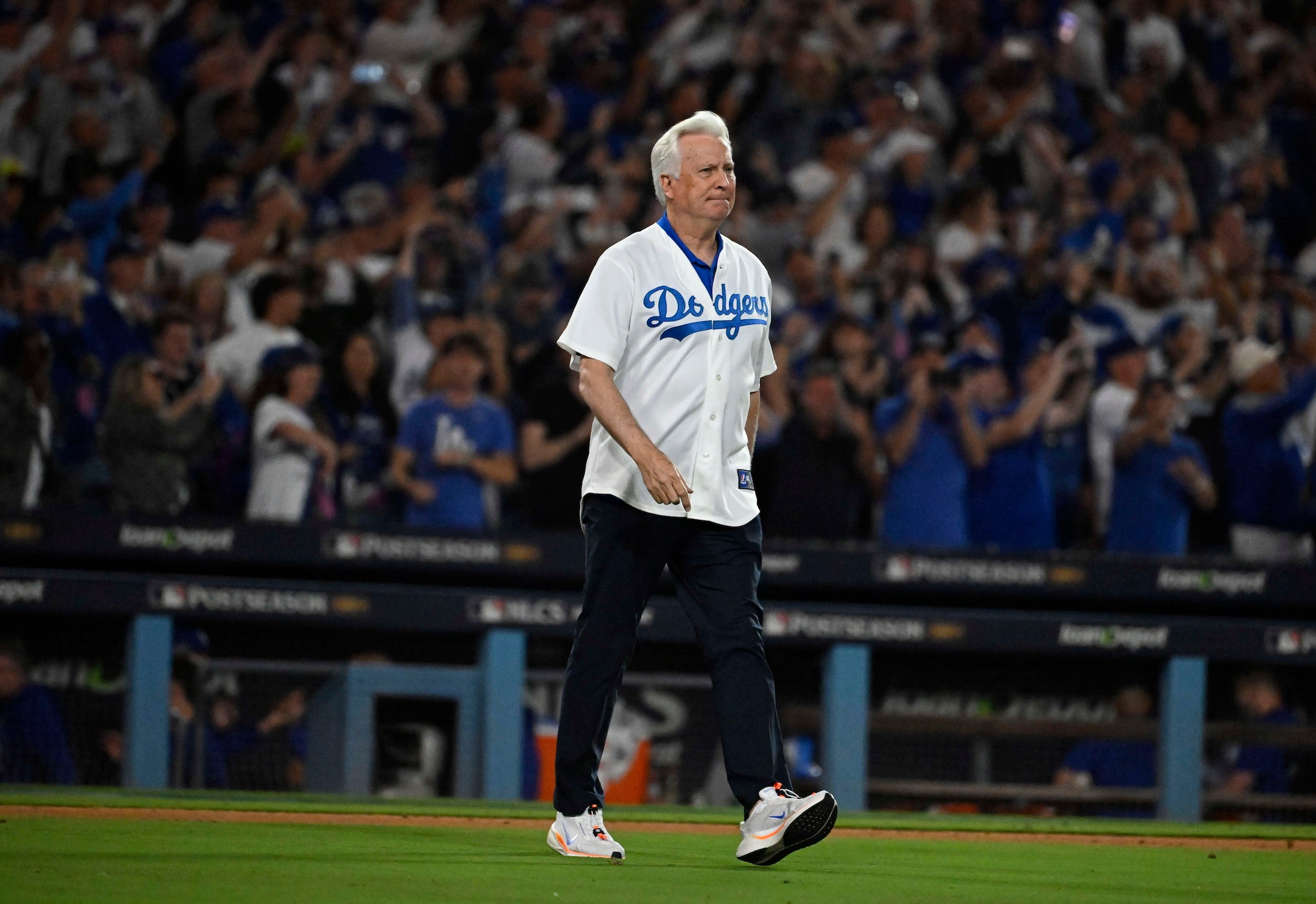 Mark Walter walks onto the field to celebrate a Dodgers playoff win