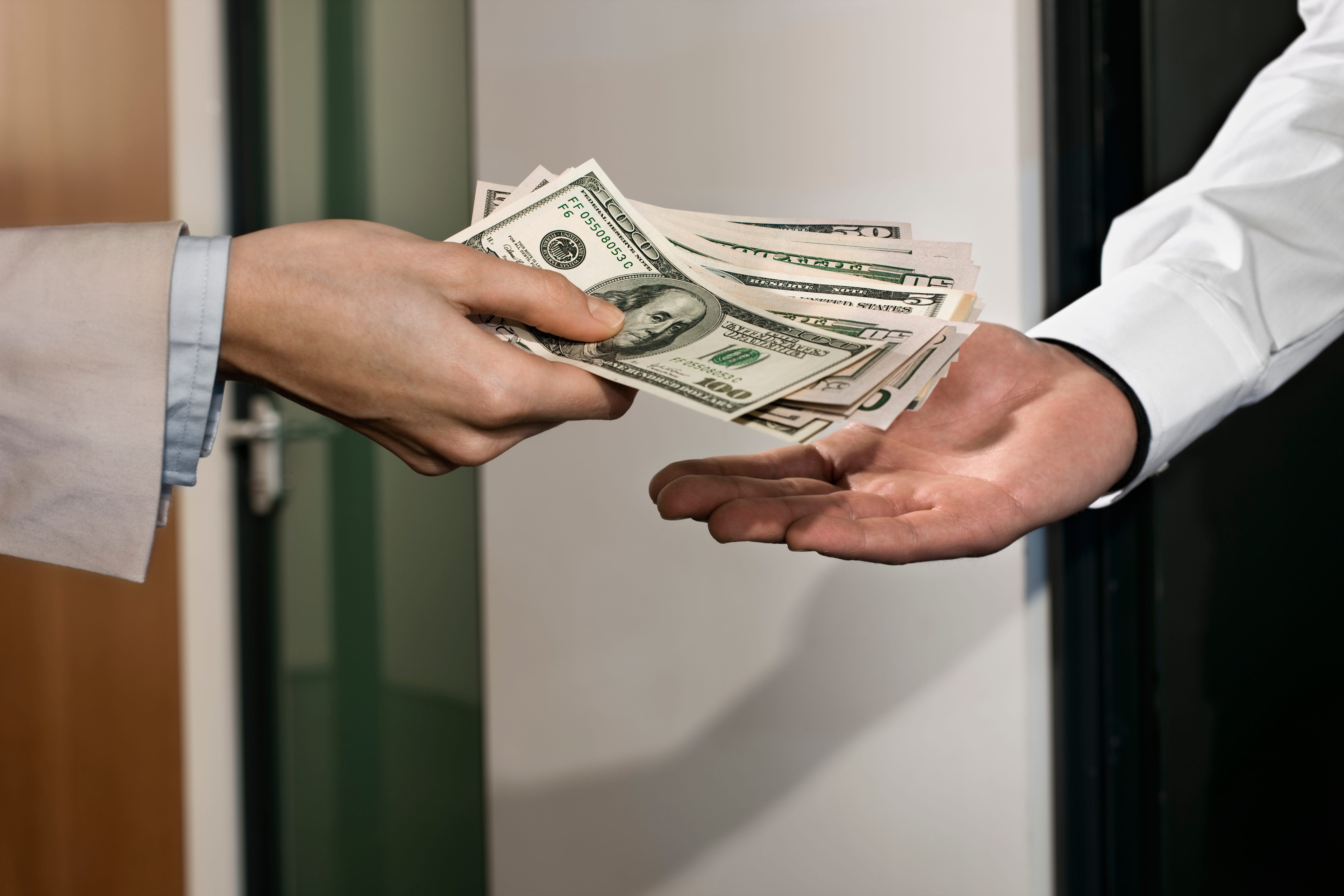 Two men exchange dollar bills.