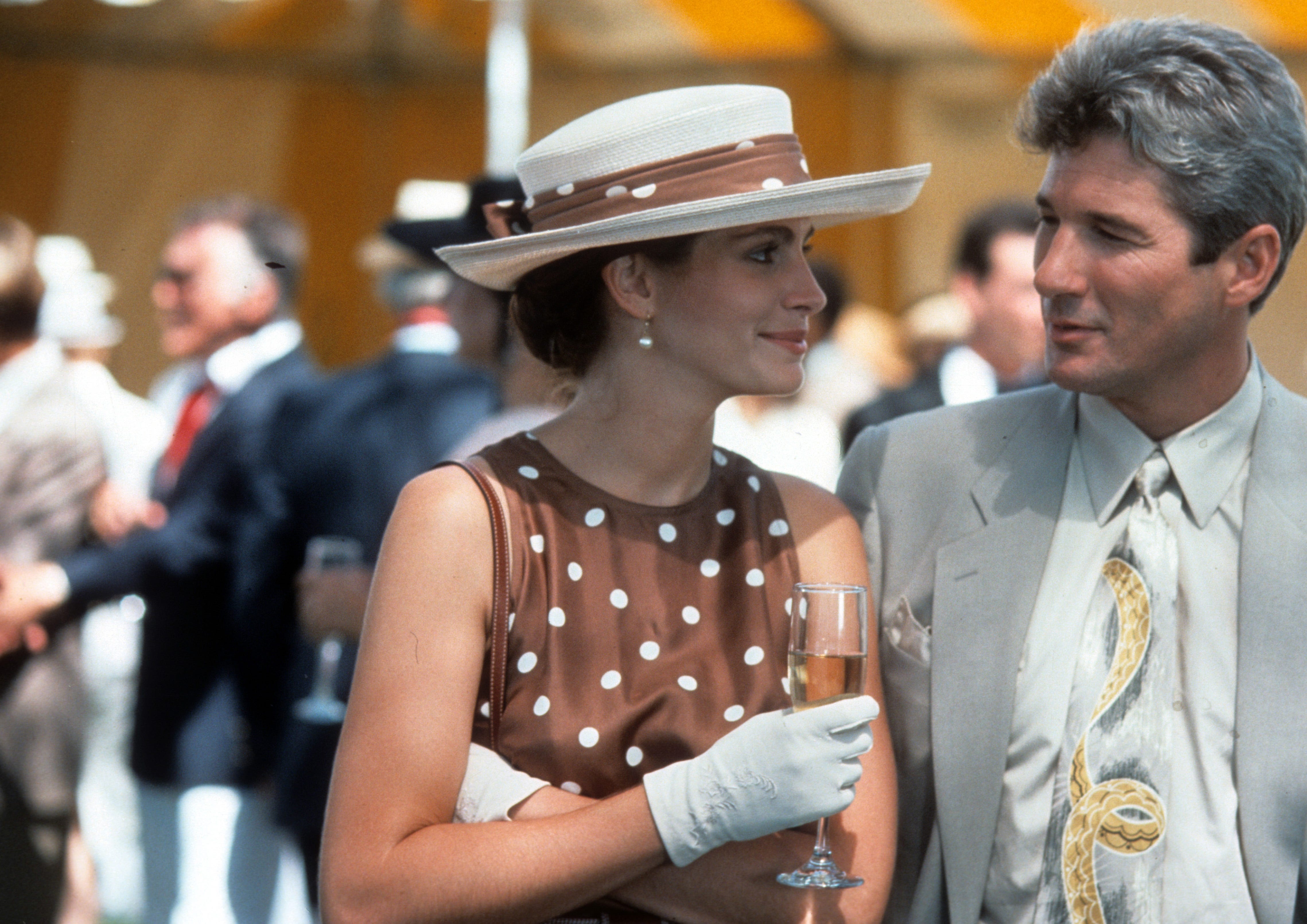 A still from "Pretty Woman" of Julia Roberts in a brown polka dot dress and Richard Gere in a gray suit