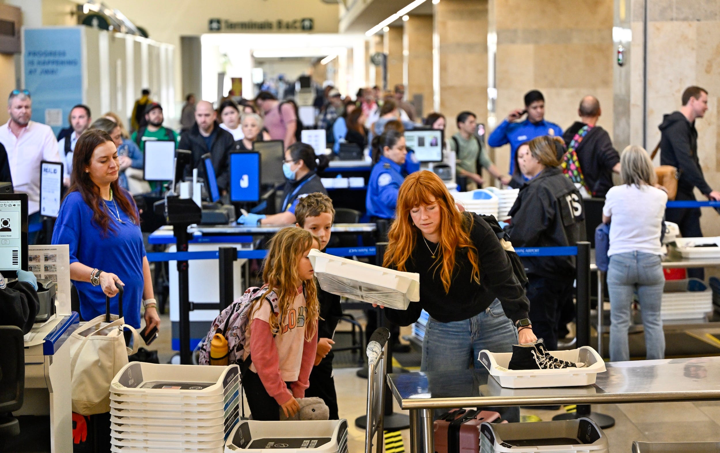 Travelers go through a TSA security checkpoint at John Wayne Airport in Santa Ana, California
