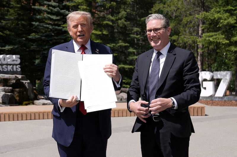 U.S. President Donald Trump holds a signed Trade Agreement with Britain during a meeting with British Prime Minister Keir Starmer, at the G7 summit.