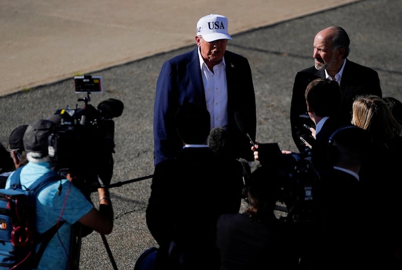 U.S. President Donald Trump stands next to U.S. Secretary of Commerce Howard Lutnick, as he speaks to members of the media, upon his arrival at Morristown Airport, in Morristown, New Jersey, U.S., July 6, 2025. REUTERS/Nathan Howard