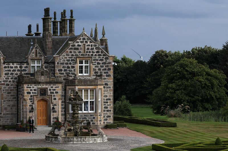 A wind turbine stands behind trees near Trump MacLeod House, after the arrival of U.S. President Donald Trump and British Prime Minister Keir Starmer, as seen from Trump International Golf Links Aberdeen, in Balmedie, Aberdeen, Scotland, Britain, July 28, 2025. REUTERS/Evelyn Hockstein