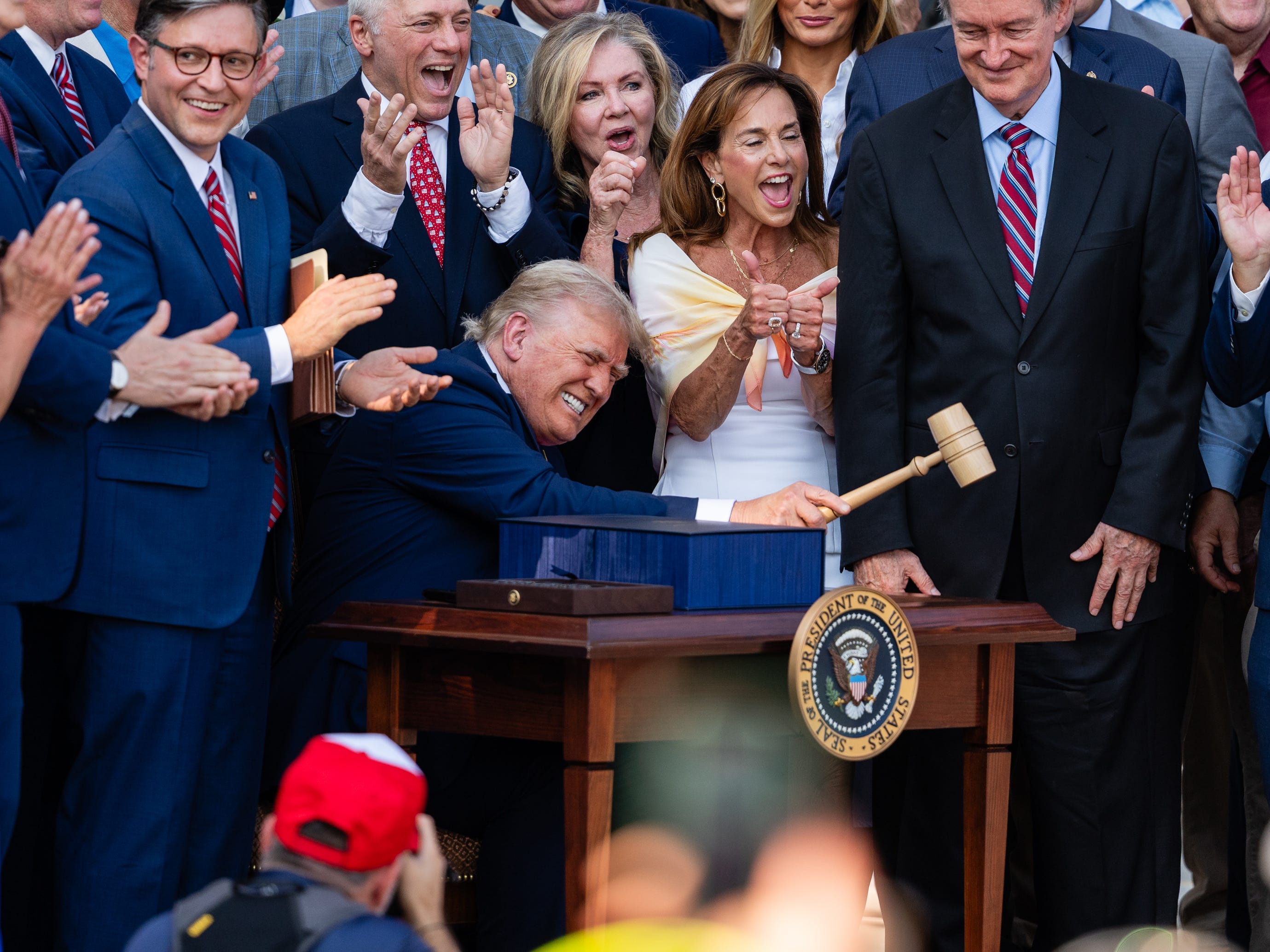 WASHINGTON, DC - JULY 04: U.S. President Donald Trump, joined by Republican lawmakers, holds a gavel after signing the "One, Big Beautiful Bill" Act into law during an Independence Day military family picnic on the South Lawn of the White House on July 04, 2025 in Washington, DC.