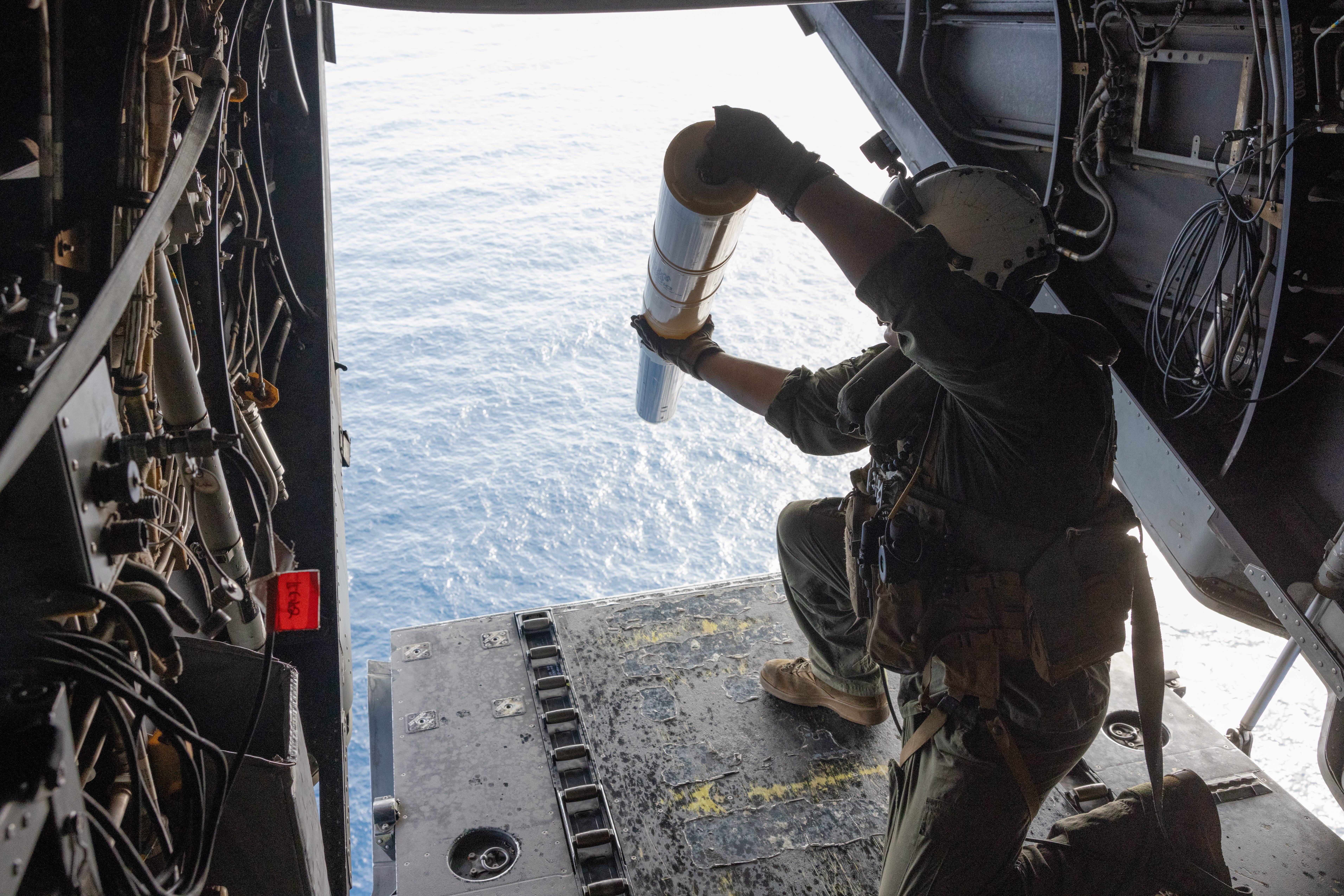 Sgt. Victor Estes , a Marine Corps aircraft crew chief, drops sonobuoys out of an MV-22B Osprey during a flight near Surface Combat Systems Center Wallops Island, Virginia, July 2, 2025.