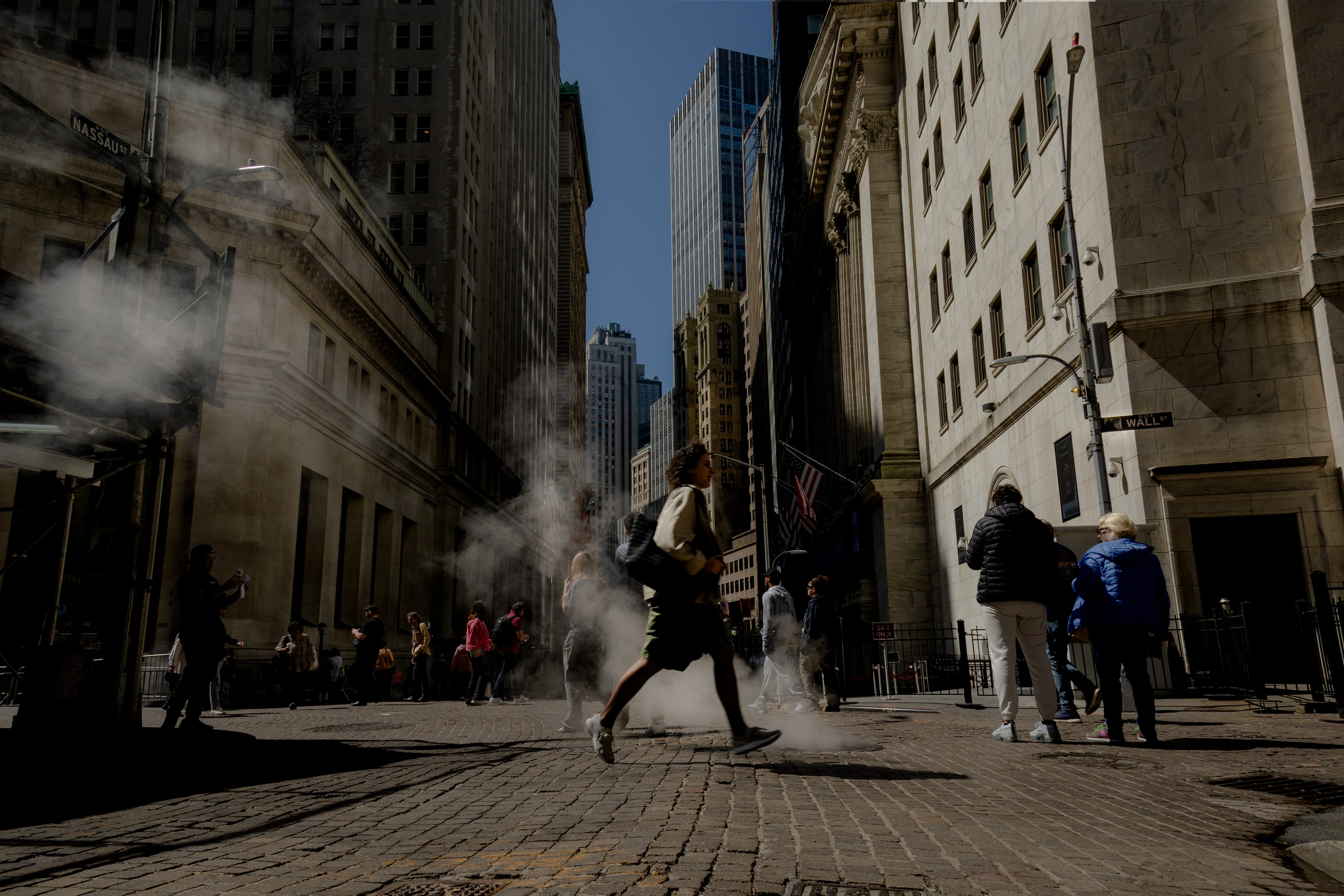 A woman crosses Wall Street