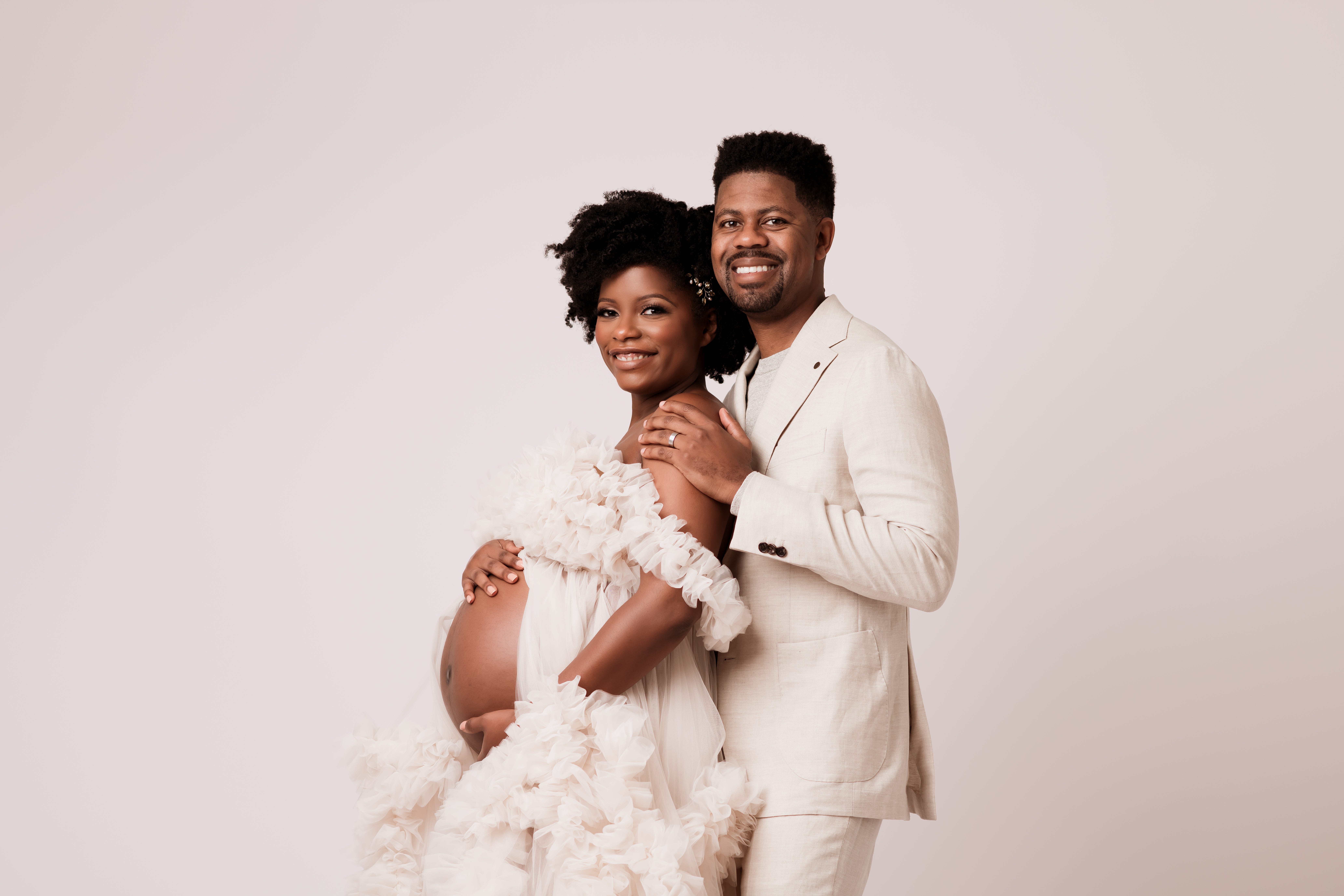 A pregnant woman and her partner dressed in white