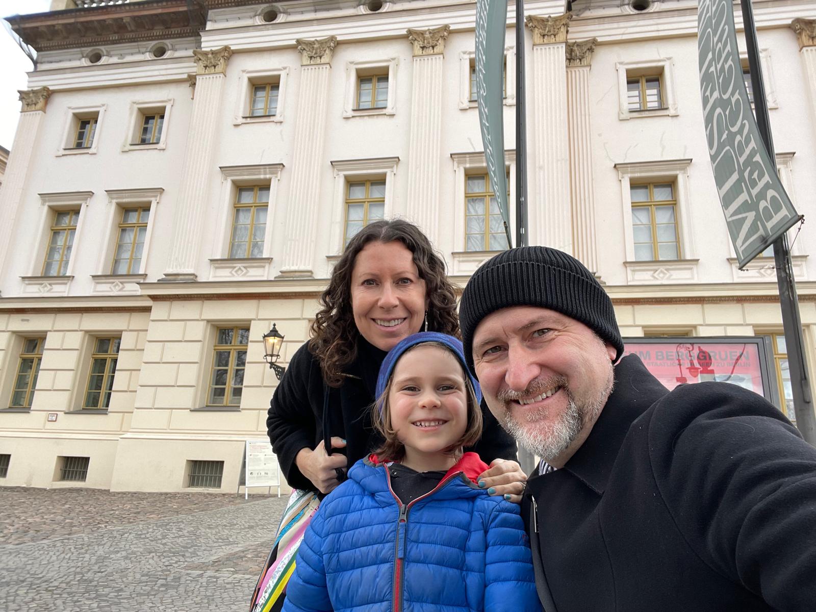 Author Liz Humphreys smiling with husband, son in Berlin in front of museum