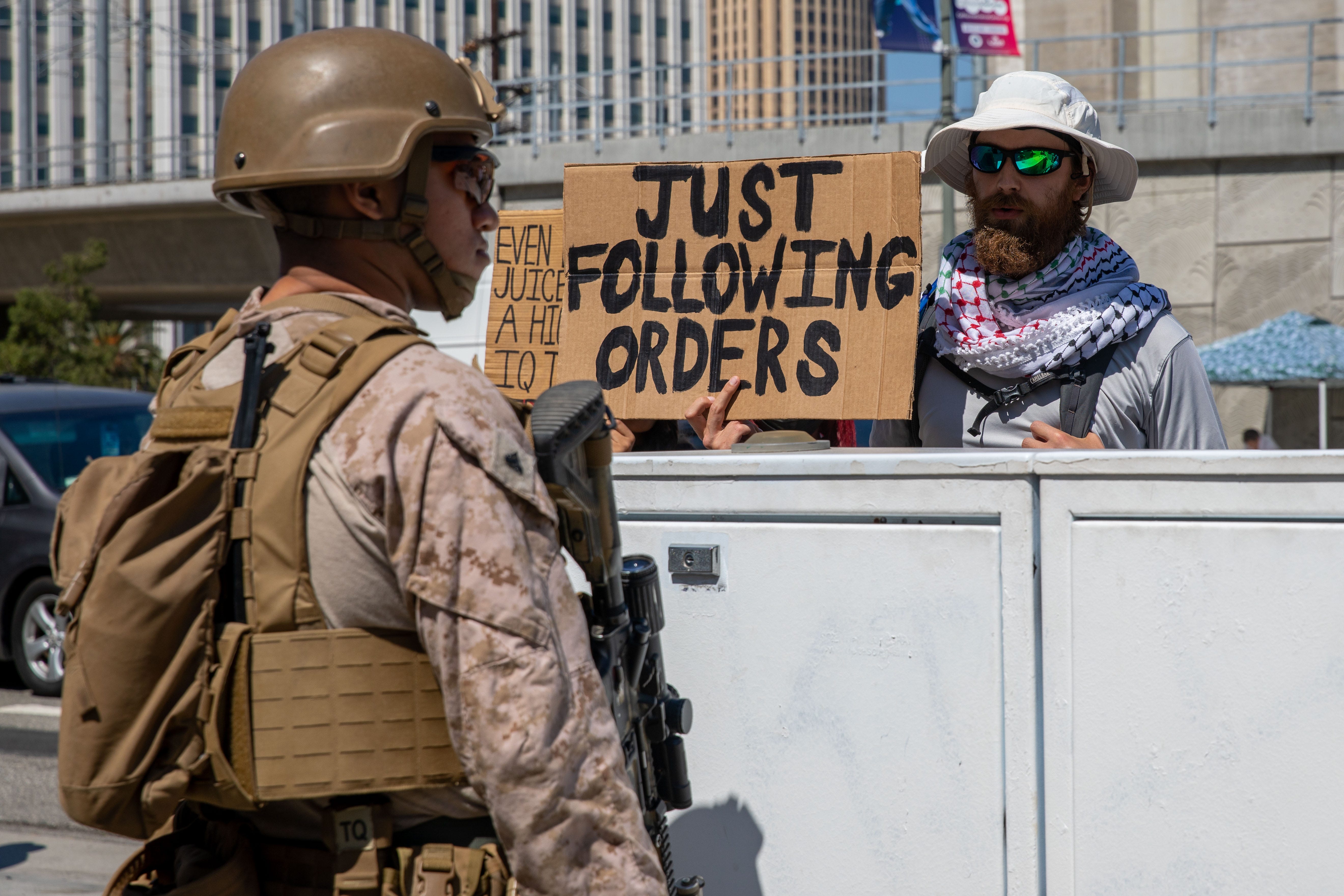 A Marine faces local protestors while guarding a federal area in Los Angeles, July 12, 2025.