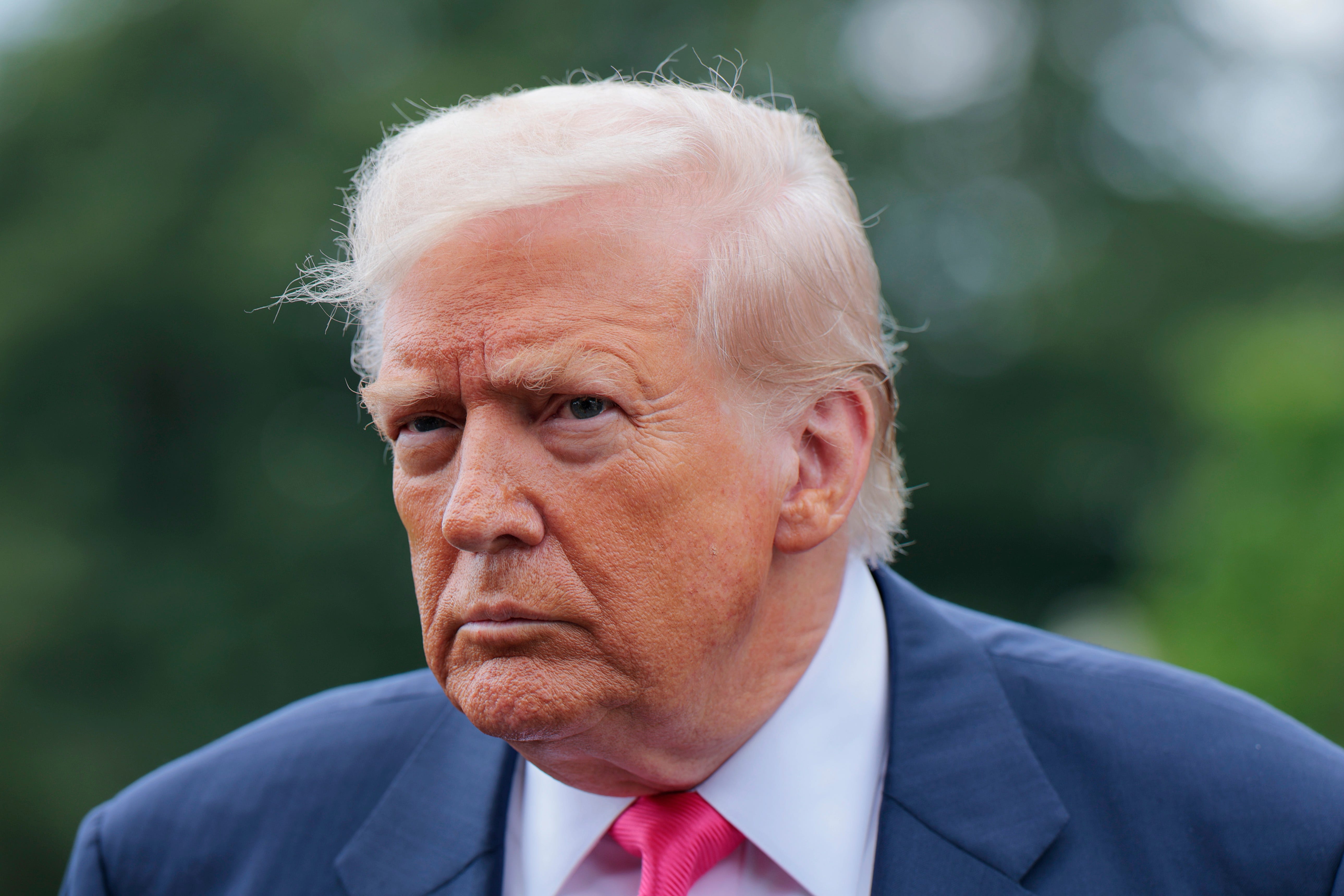 Donald Trump in a blue suit and red tie.
