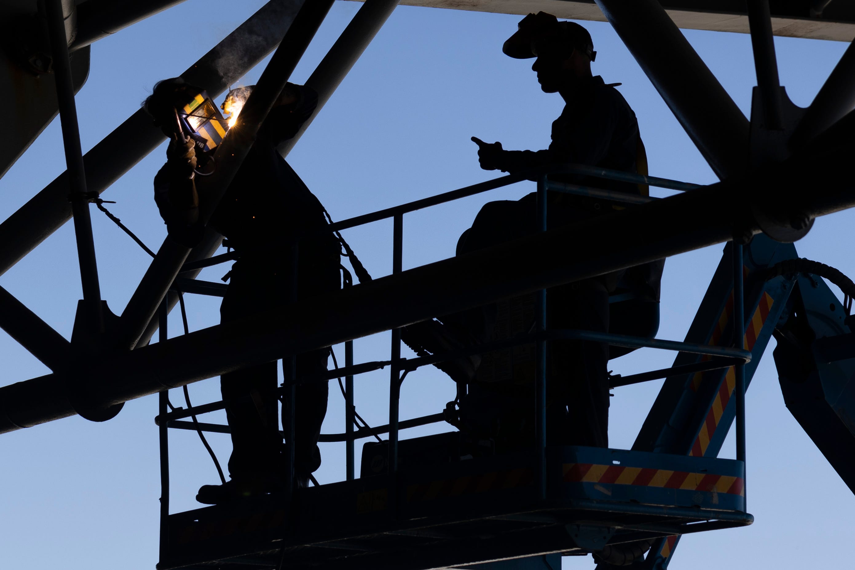 Sailors assigned to the amphibious assault ship USS Wasp weld struts on the ship's port aircraft elevator, Oct. 9, 2024.