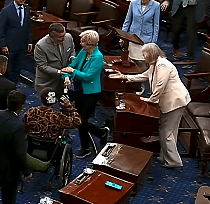 Senators rush to help Warren off the floor after her tumble.
