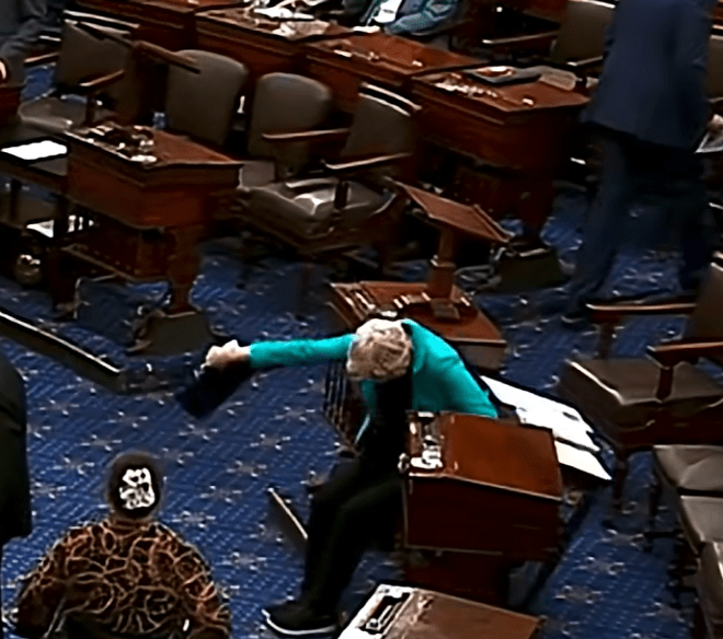 Warren falls to the ground during the Israel resolution vote.