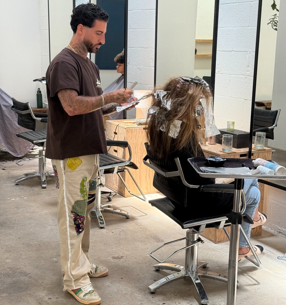 Hair colorist applying foil highlights to a client's hair.