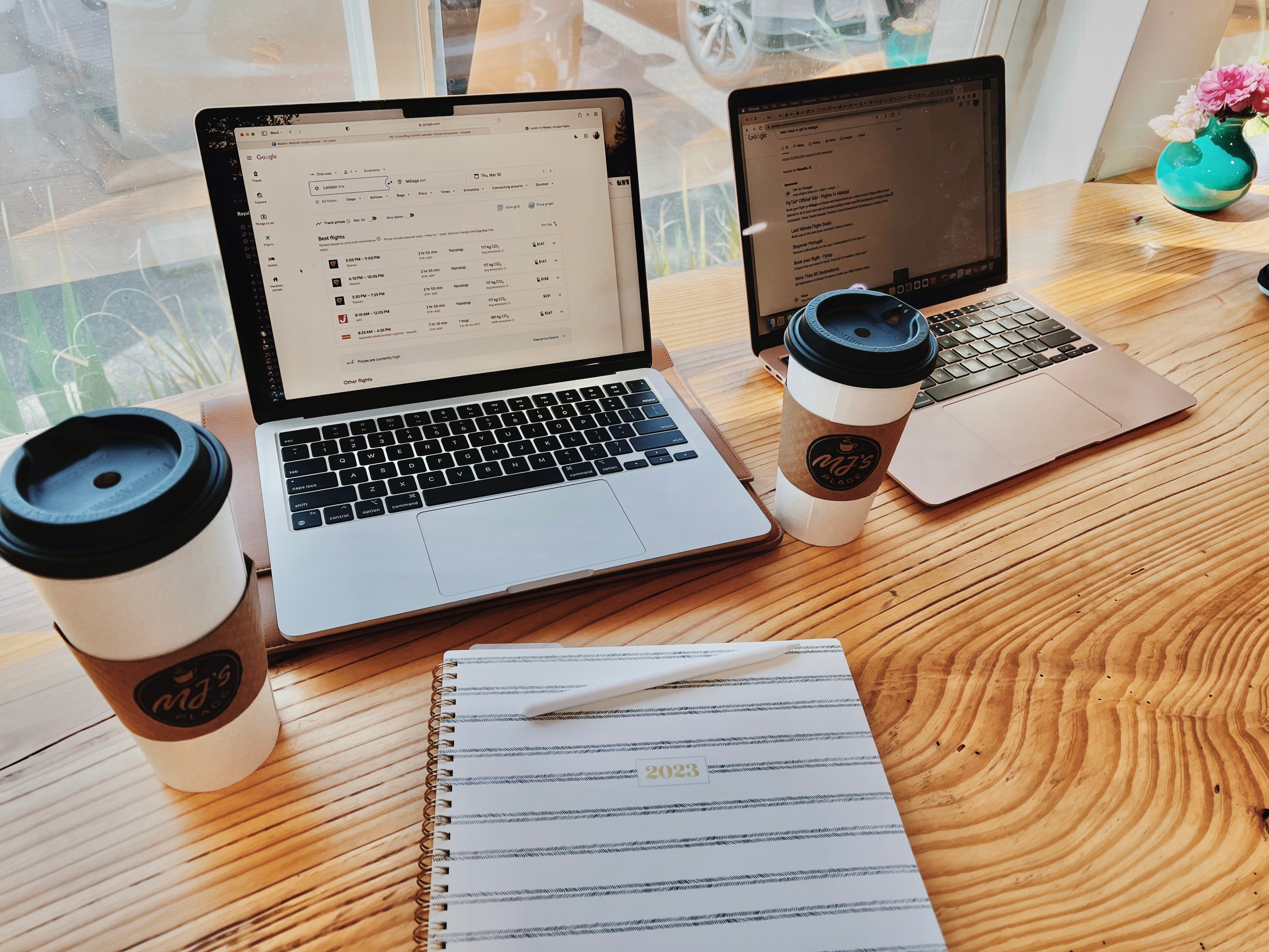 Laptops, coffees, paper on table