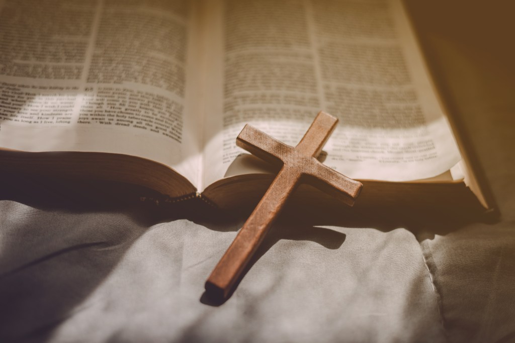 Wooden cross on open Bible.