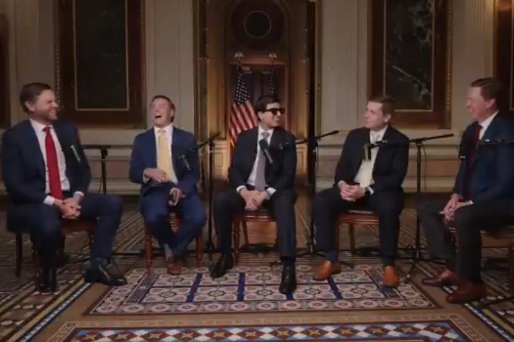 Five men in suits sitting for a podcast interview.