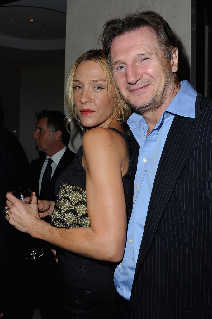 Liam Neeson in a pin-striped suit and blue shirt, Freya St Johnson in a black dress.