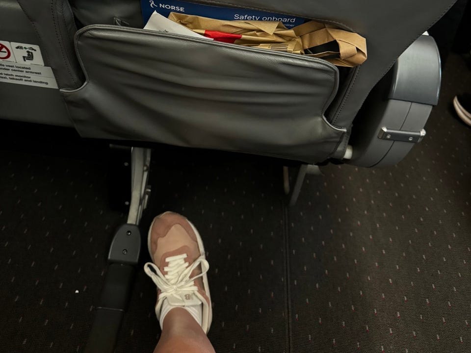 Authors foot in front of stuffed seat back in front of her showing she had room for her feet