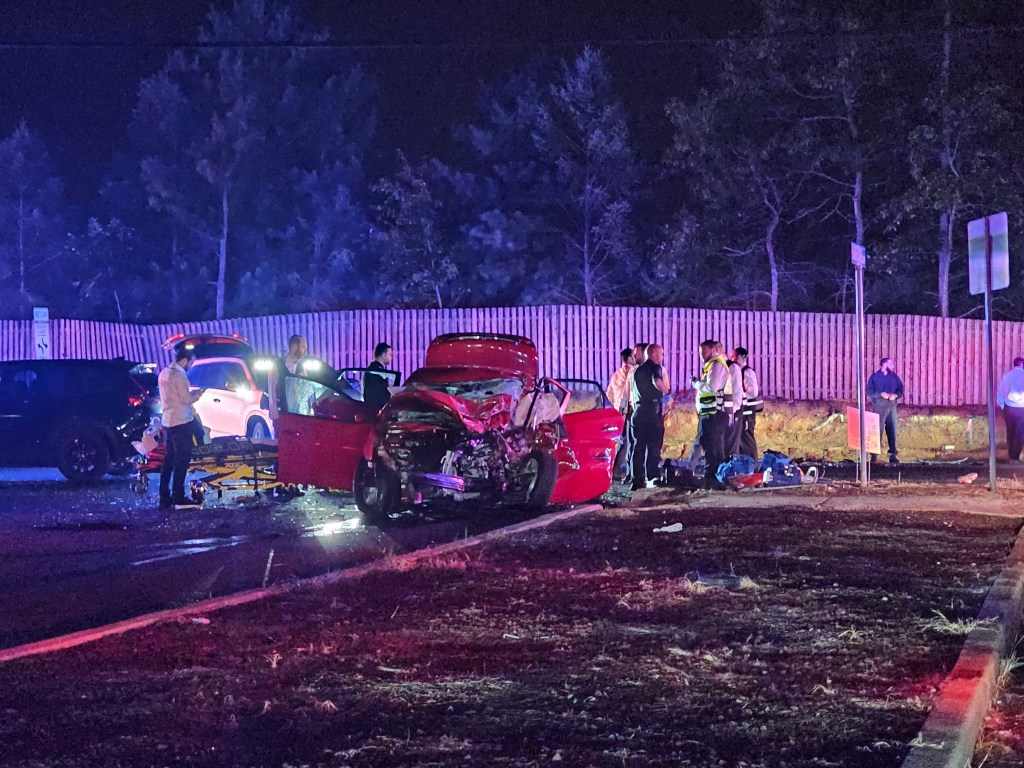 Aftermath of a two-car collision at night, with emergency personnel on scene.