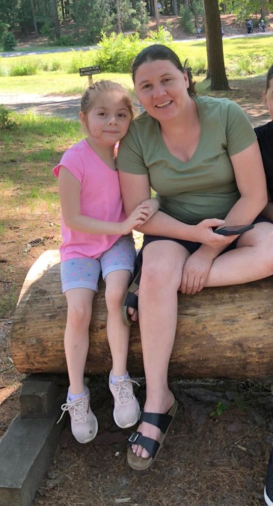 Maria Pleitez and Dayanara Cortes sitting on a log.