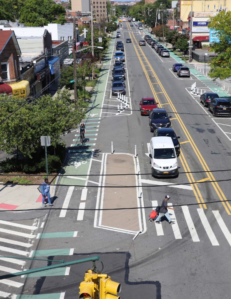 Aerial view of a city street with daylighting and protected bike lanes.