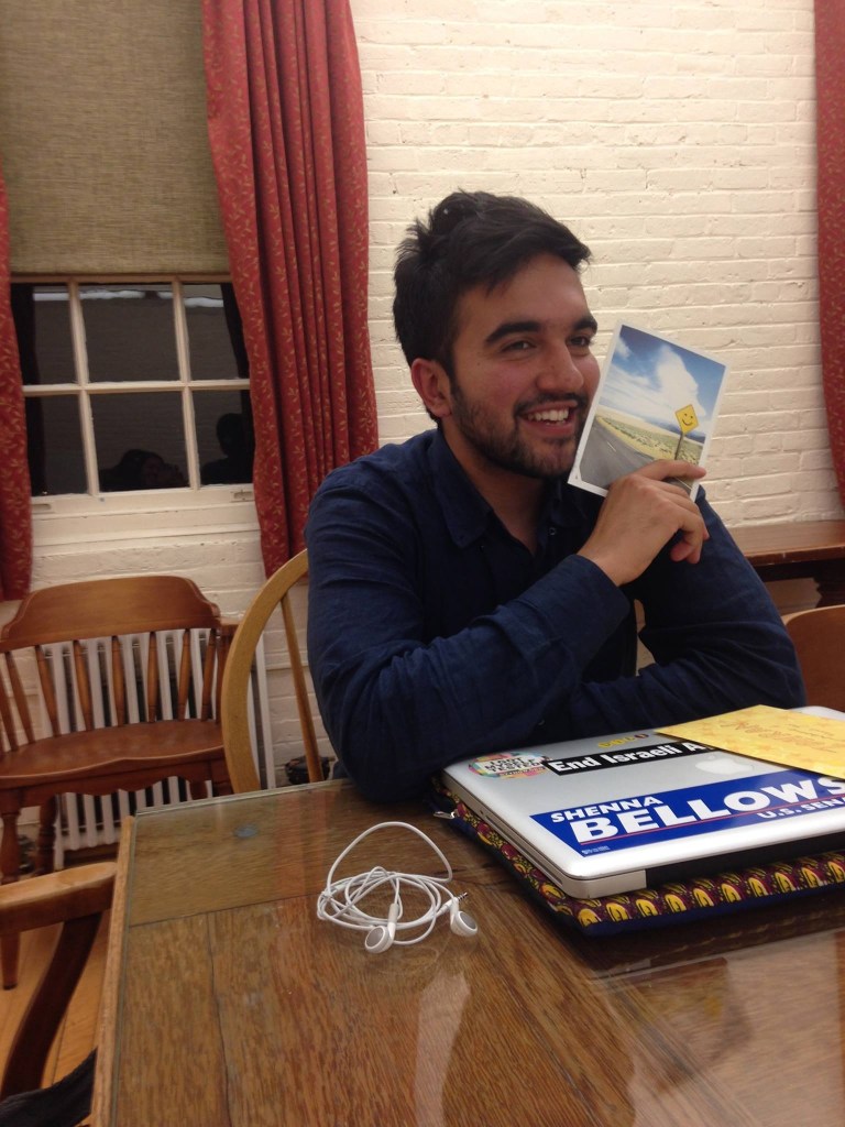 Smiling graduate holding a postcard.