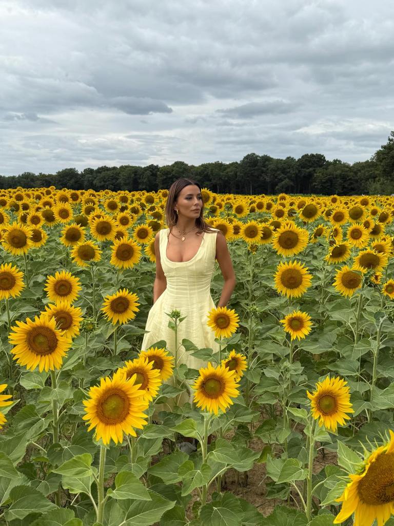 Eva Longoria contemplates a field of sunflowers on a photo shoot.
