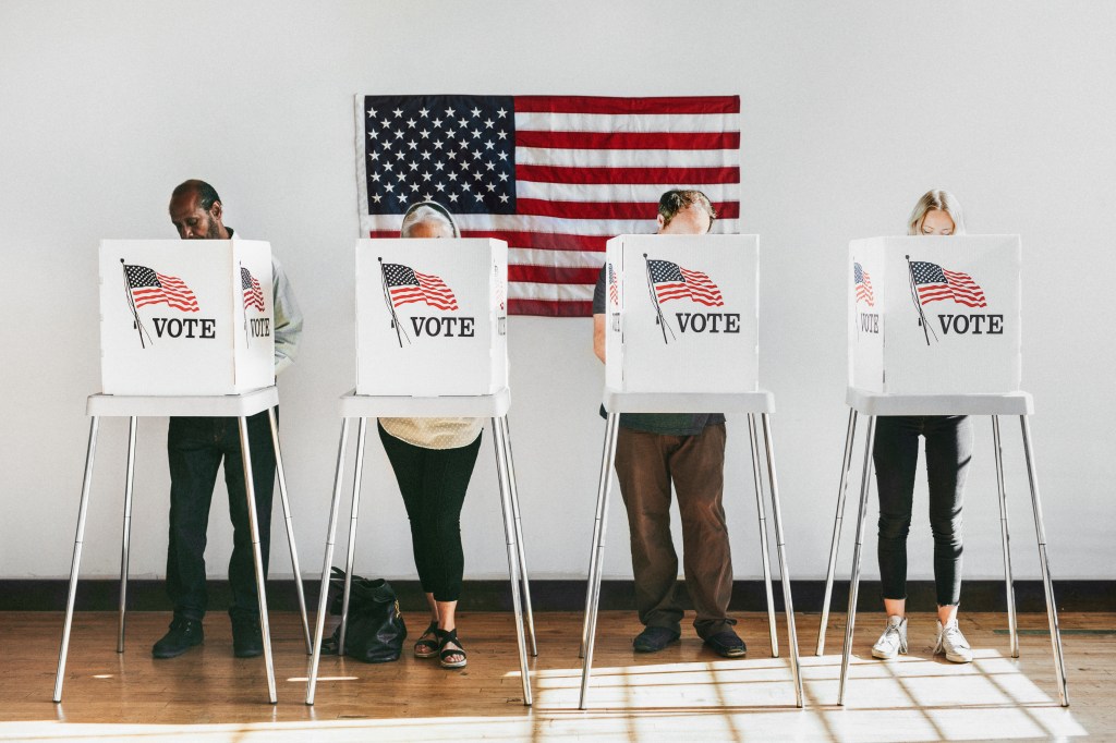 Four people voting at a polling place.