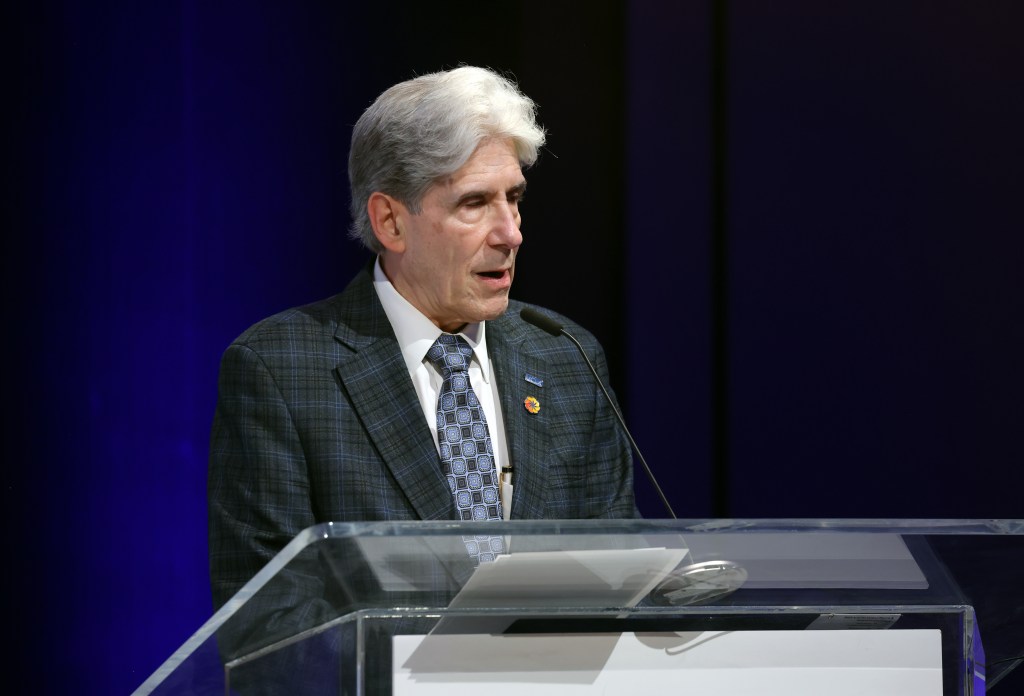 Julio Frenk speaking at a podium.