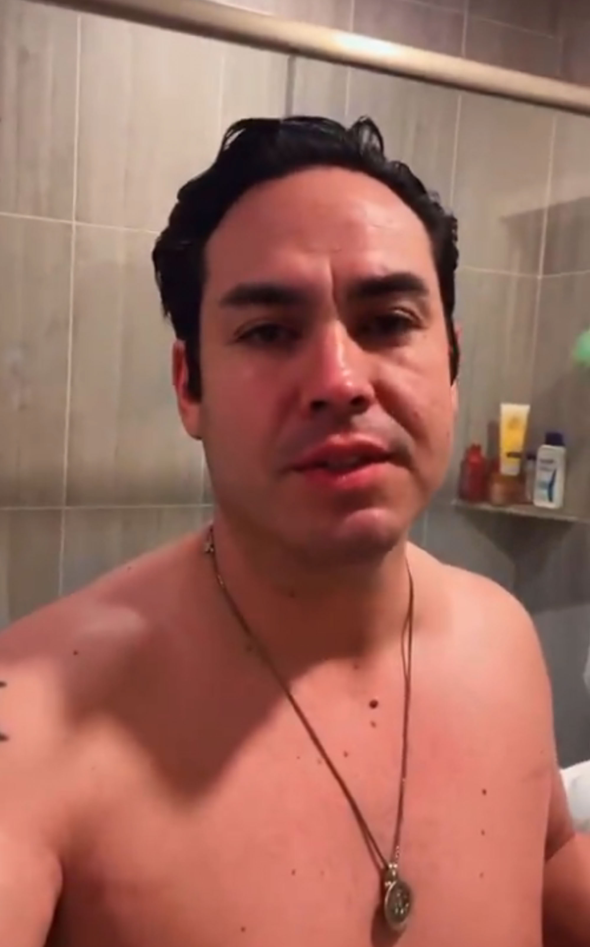 Eric Meza shirtless outside a shower. 