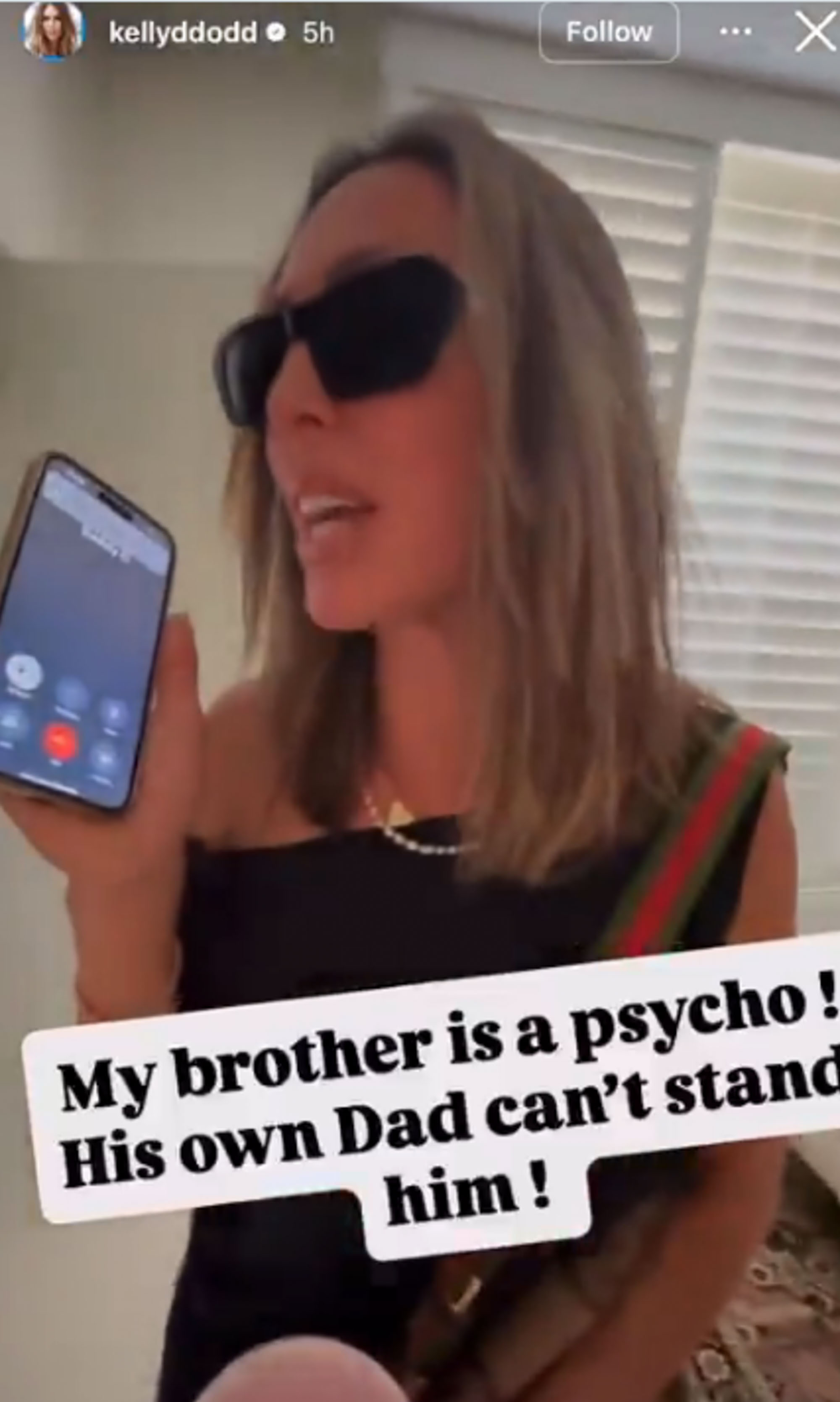 Kelly Dodd talks on a cell phone in sunglasses. 