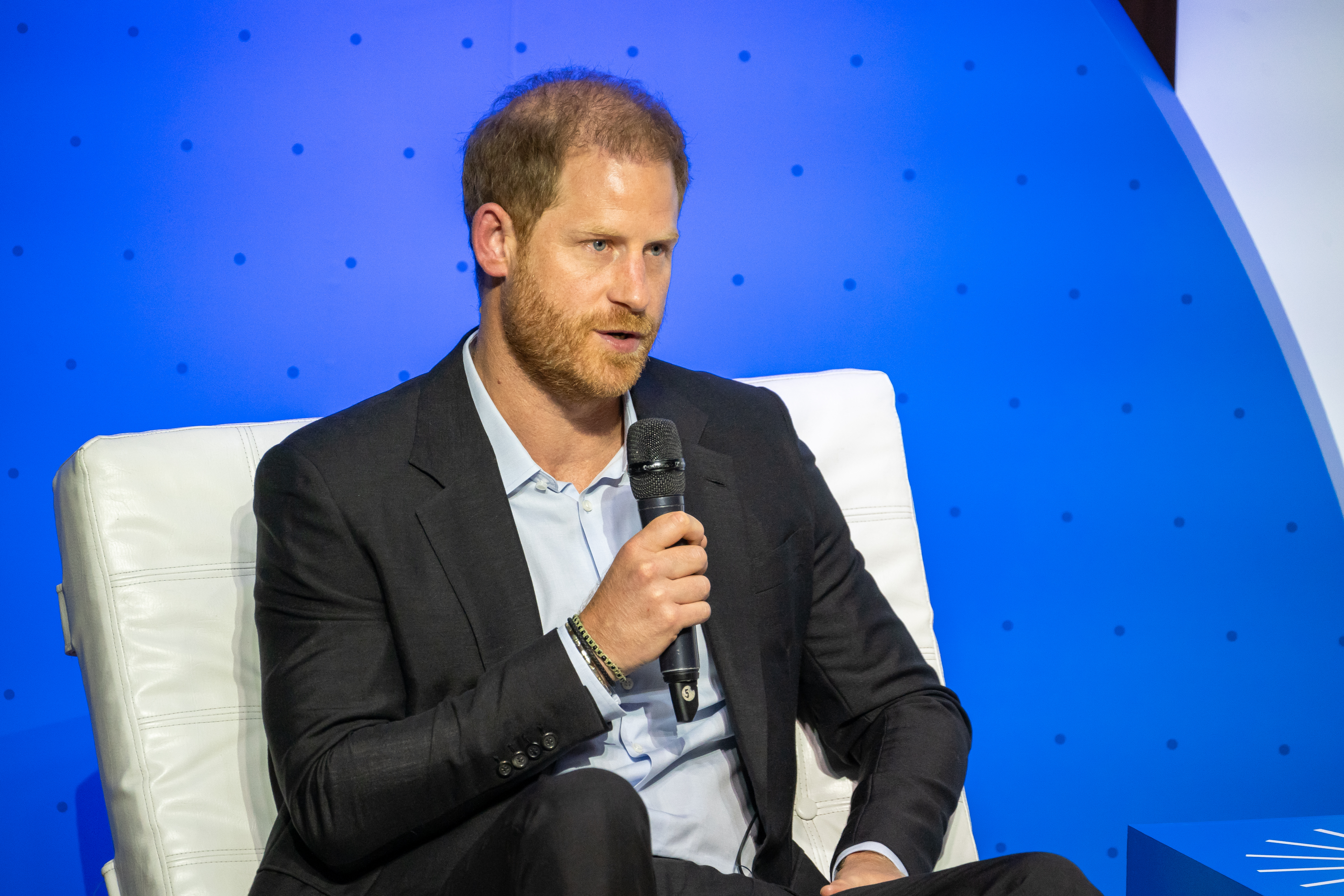 Prince Harry speaks into a mic. 