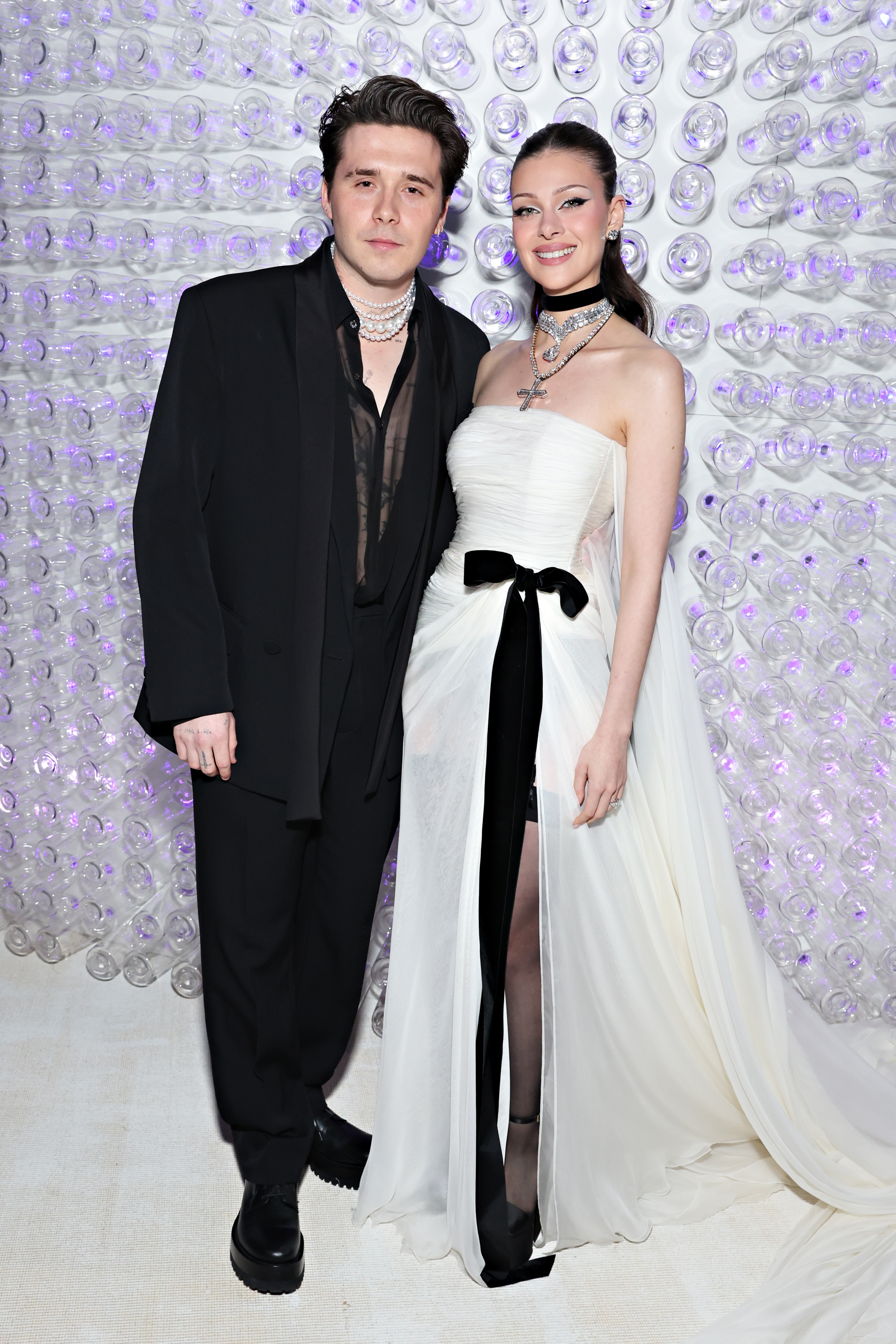Nicola Peltz and Brooklyn Beckham at a formal event. 