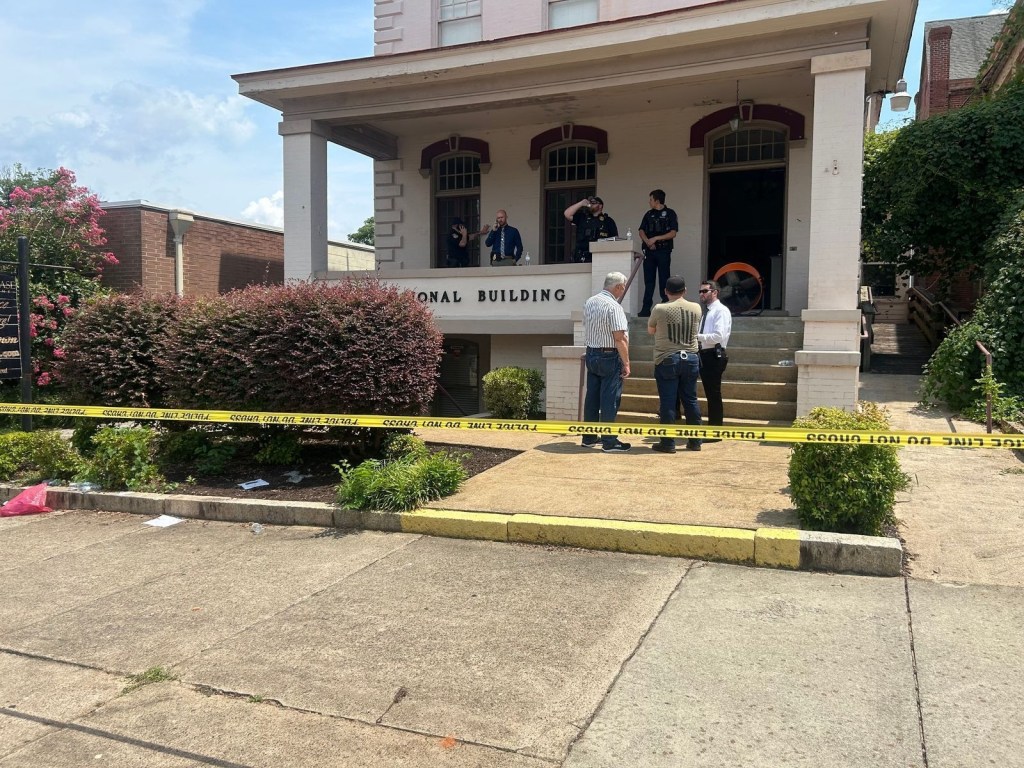 Police investigating a crime scene outside a building.
