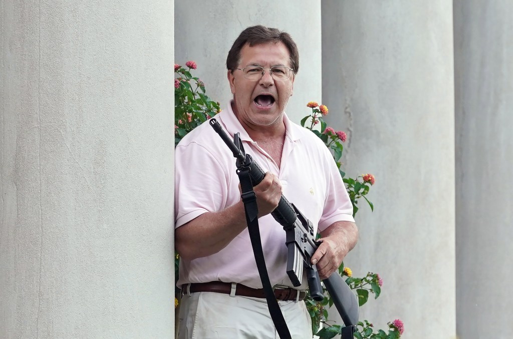 Man with AR-15 rifle confronting protesters.