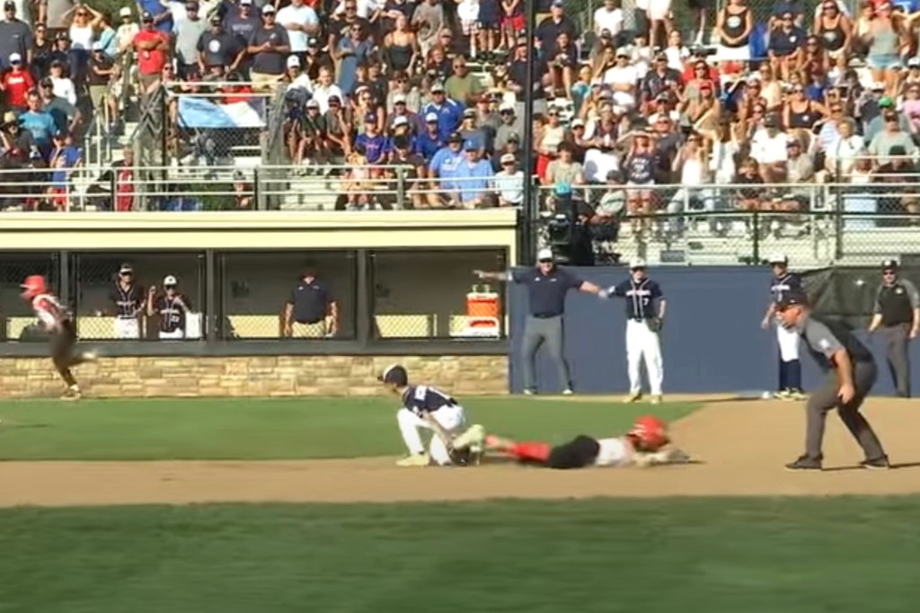 Baseball player sliding into home plate during a game.
