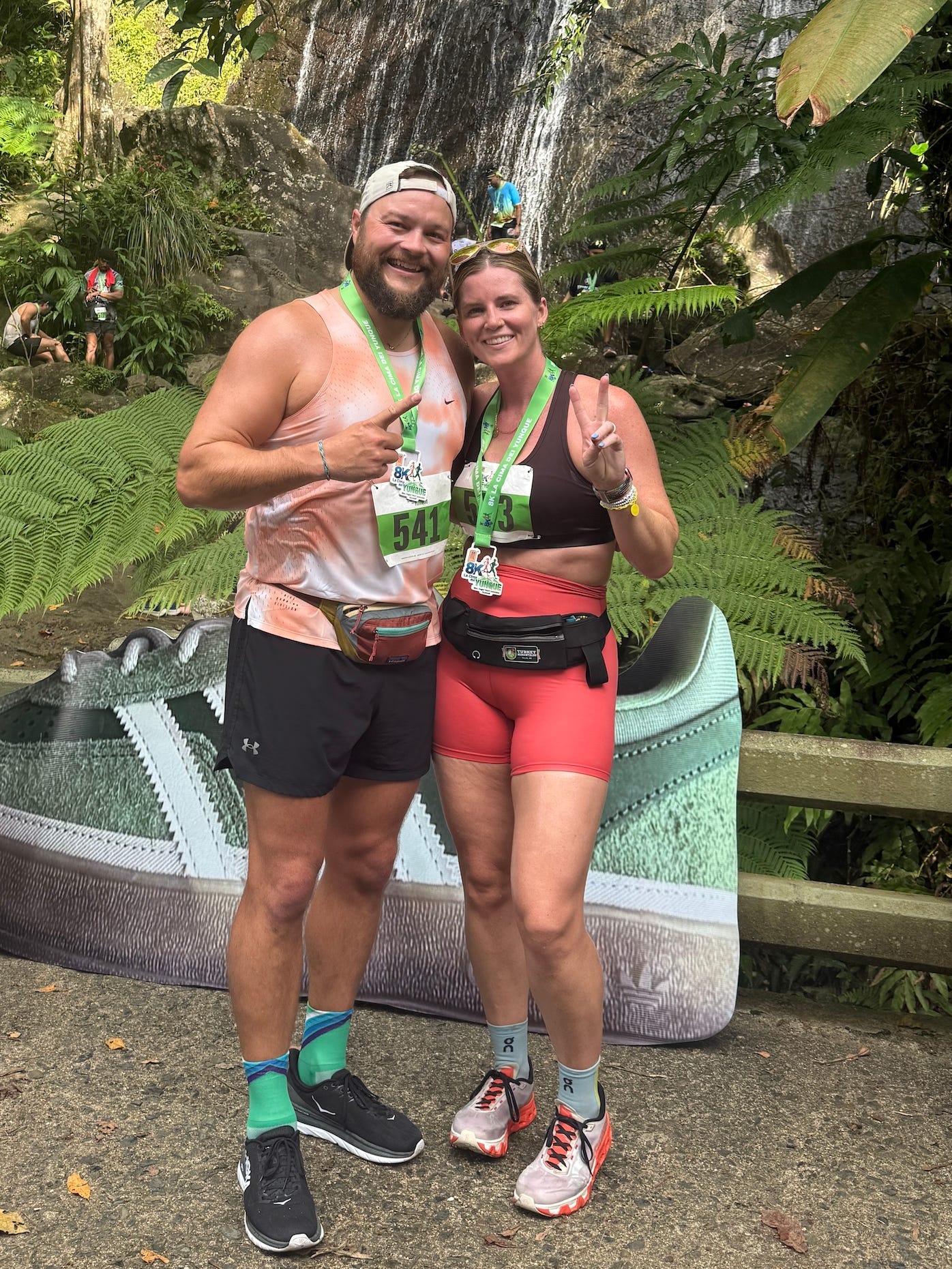 A man and woman posing with medals after a run.