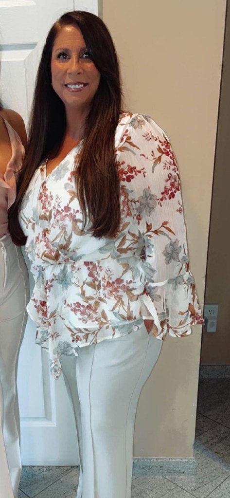 cathy gabrielli in white pants and white shirt with multicolored flowers