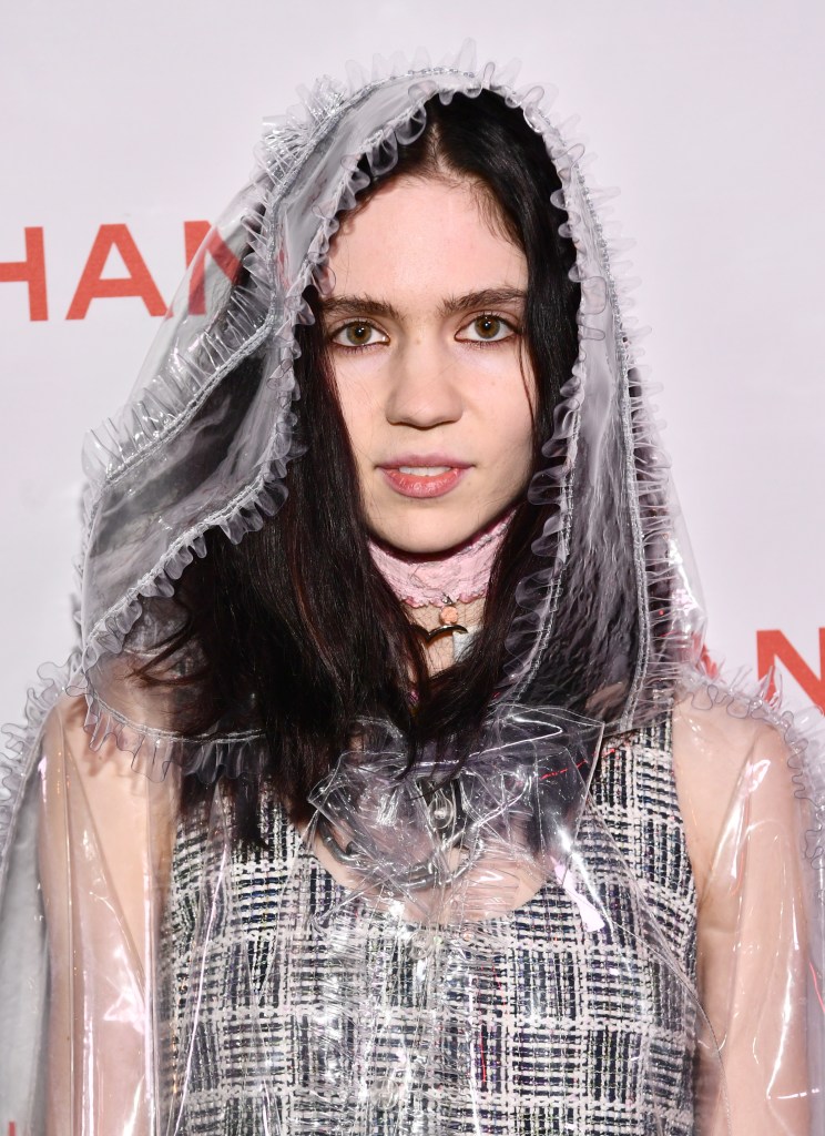 Grimes at a Chanel party wearing a transparent raincoat.