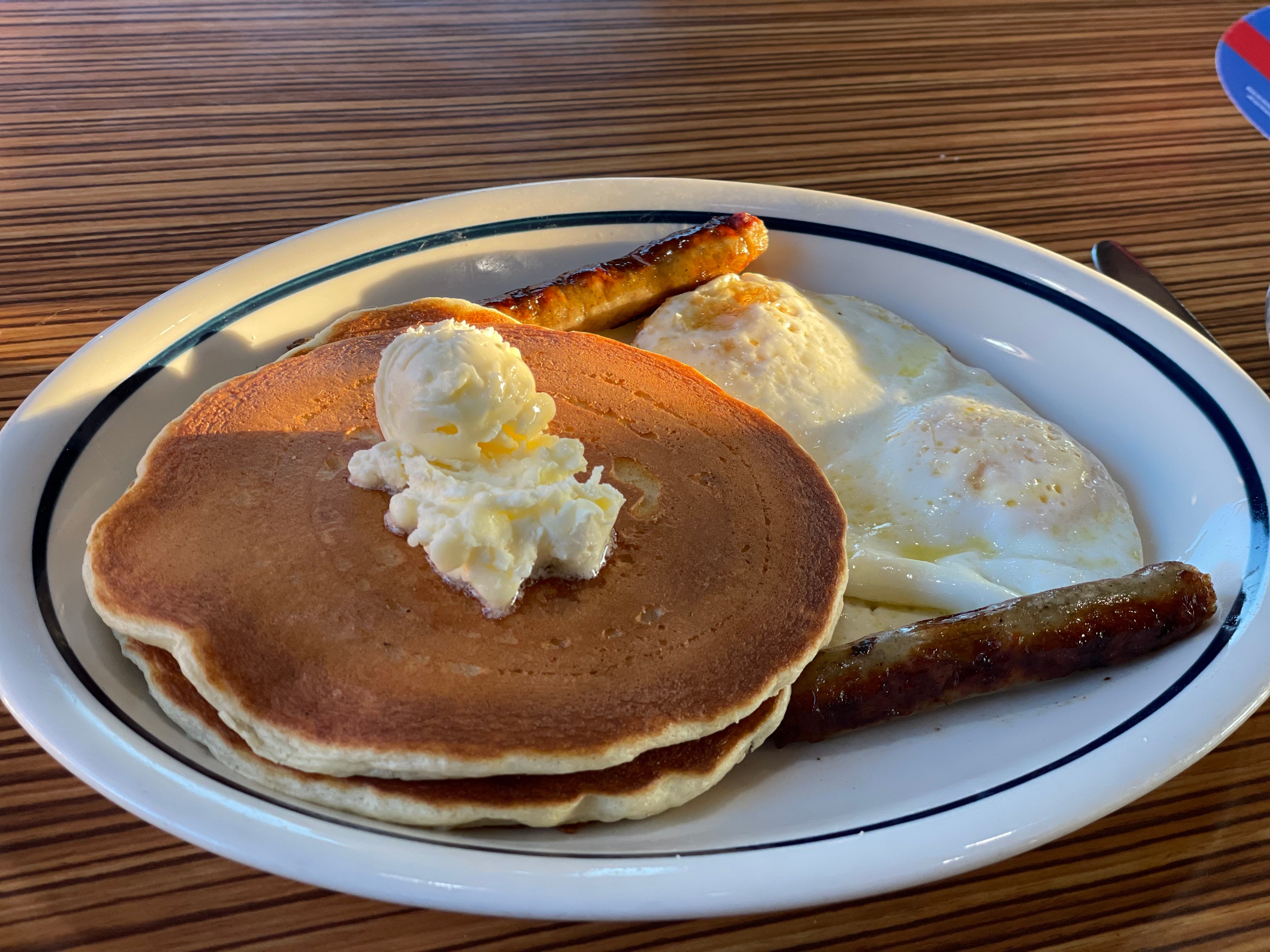 Pancakes, egg, sausage on plate at IHOP