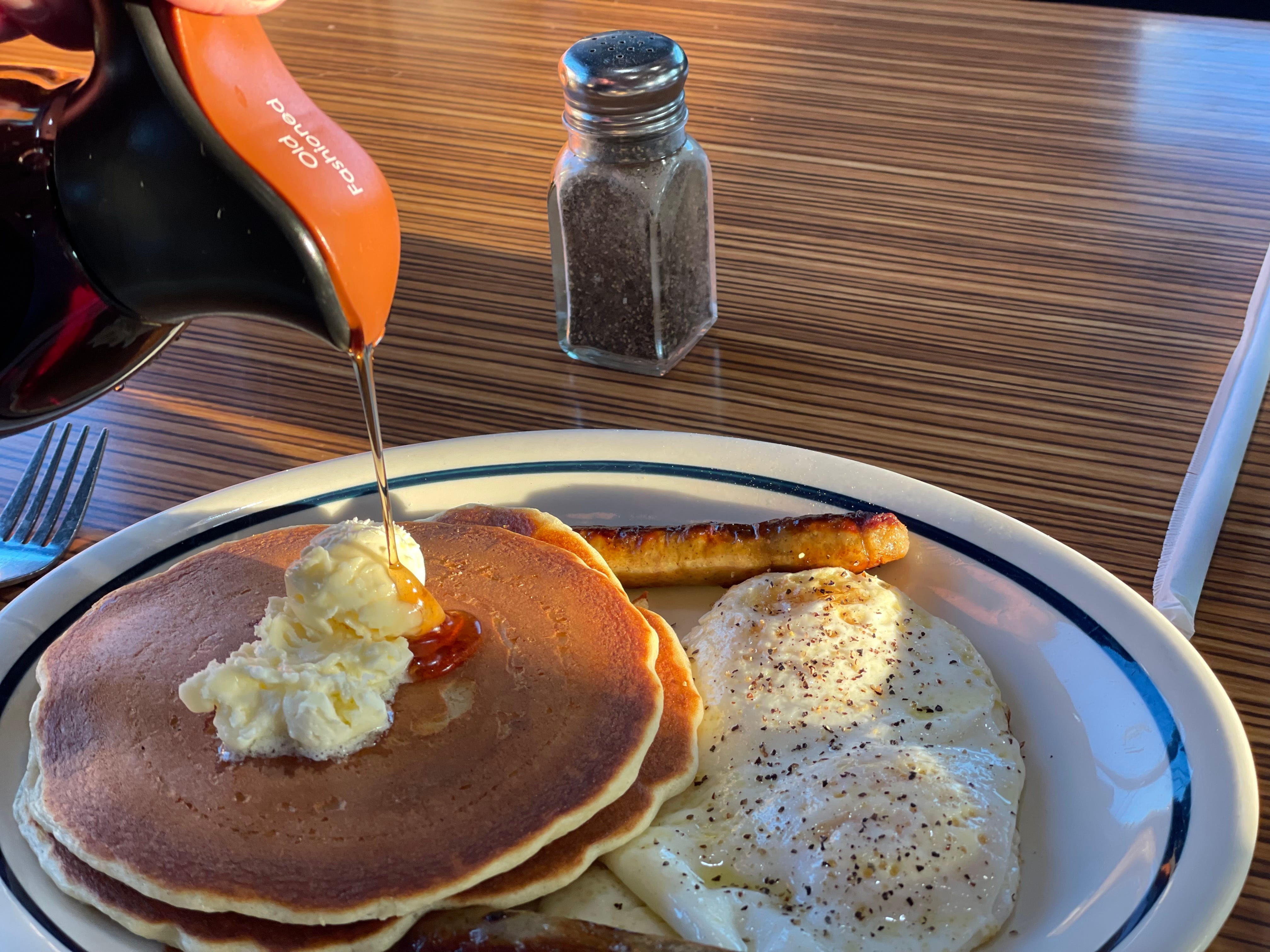 Pouring syrup on pancakes stack at IHOP