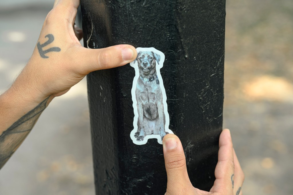 Nick places a sticker on a pole. 