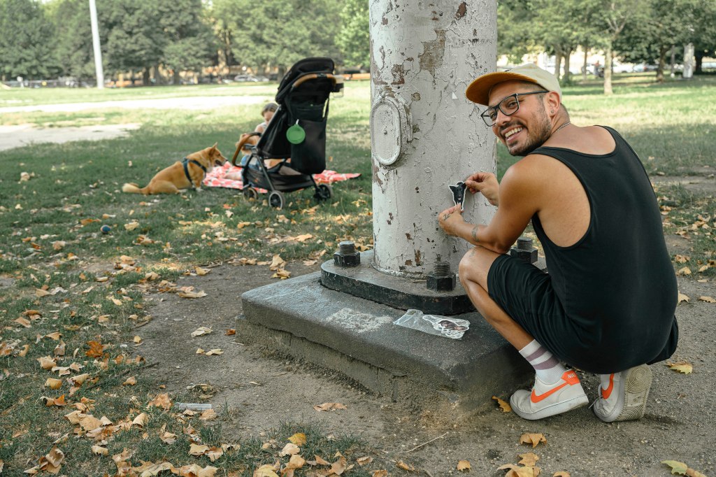 Nick places a sticker on a pole.
