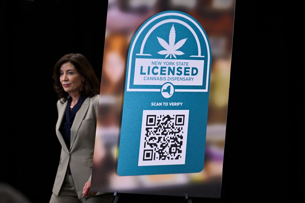 Gov. Hochul at a cannabis enforcement announcement, with a New York State Licensed Cannabis Dispensary sign.
