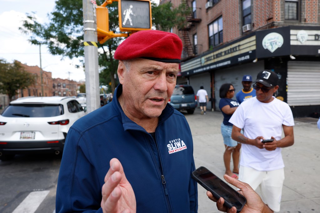 Curtis Sliwa, mayoral candidate, being interviewed on a city street.