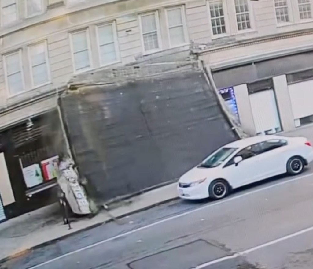 Concrete awning collapsed onto a Brooklyn sidewalk near a white car.