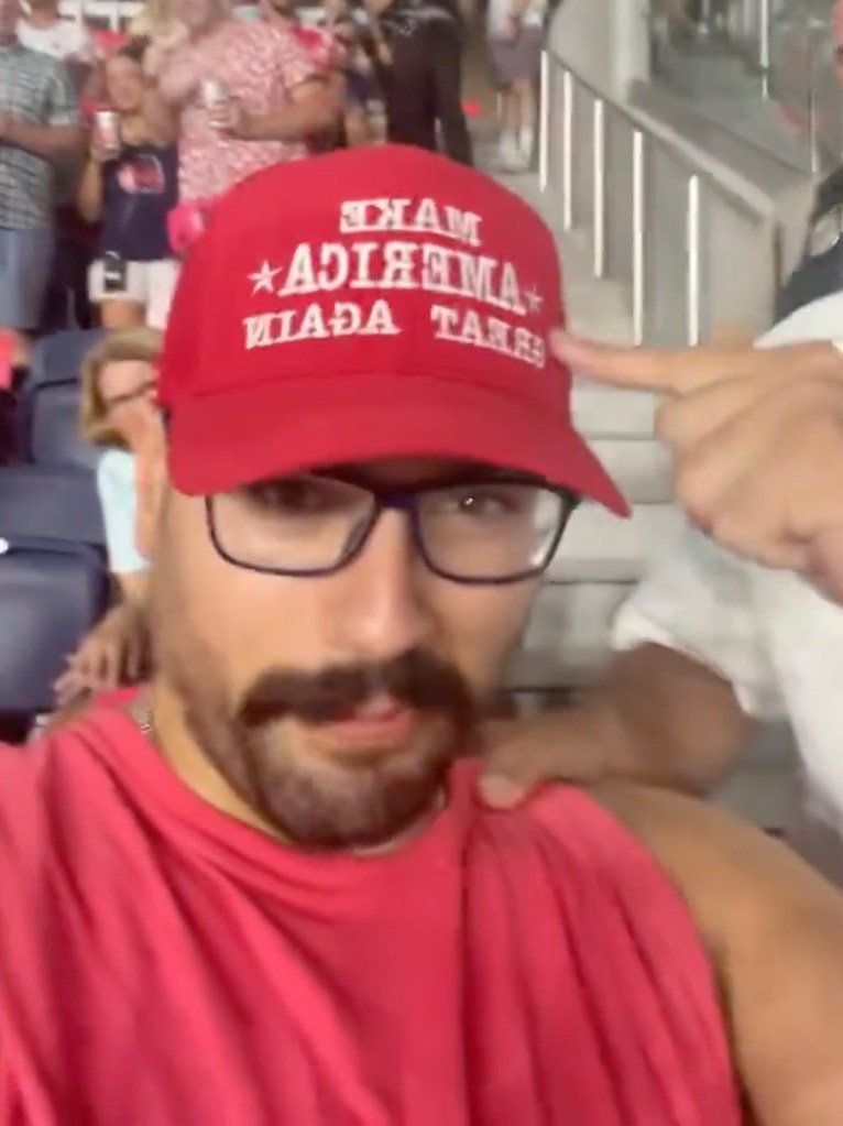 Man wearing a MAGA hat at a soccer game.