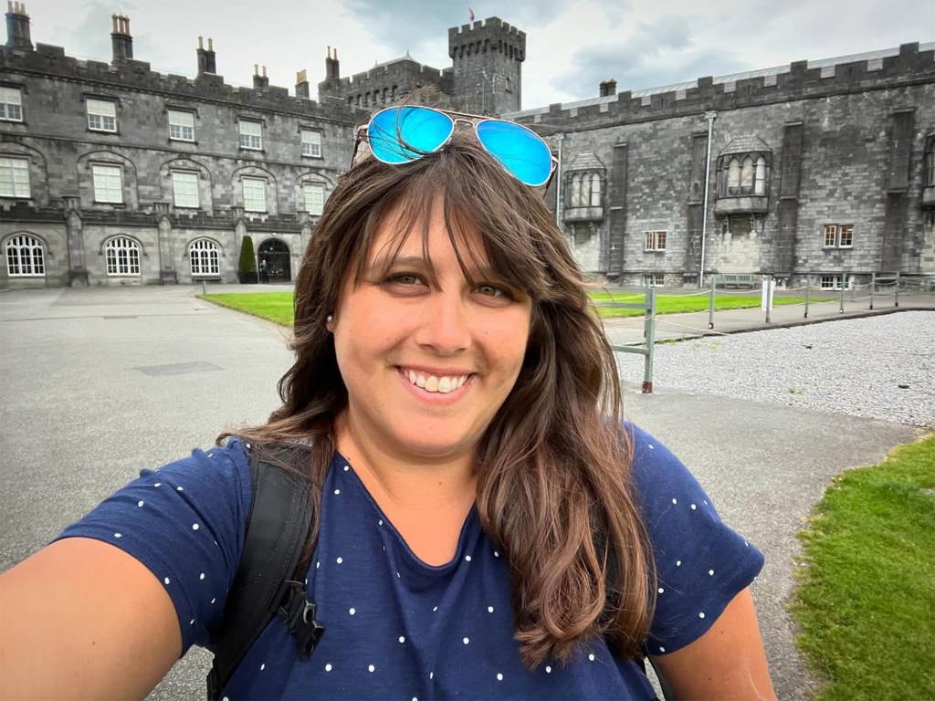 Selfie of a woman in front of a castle.