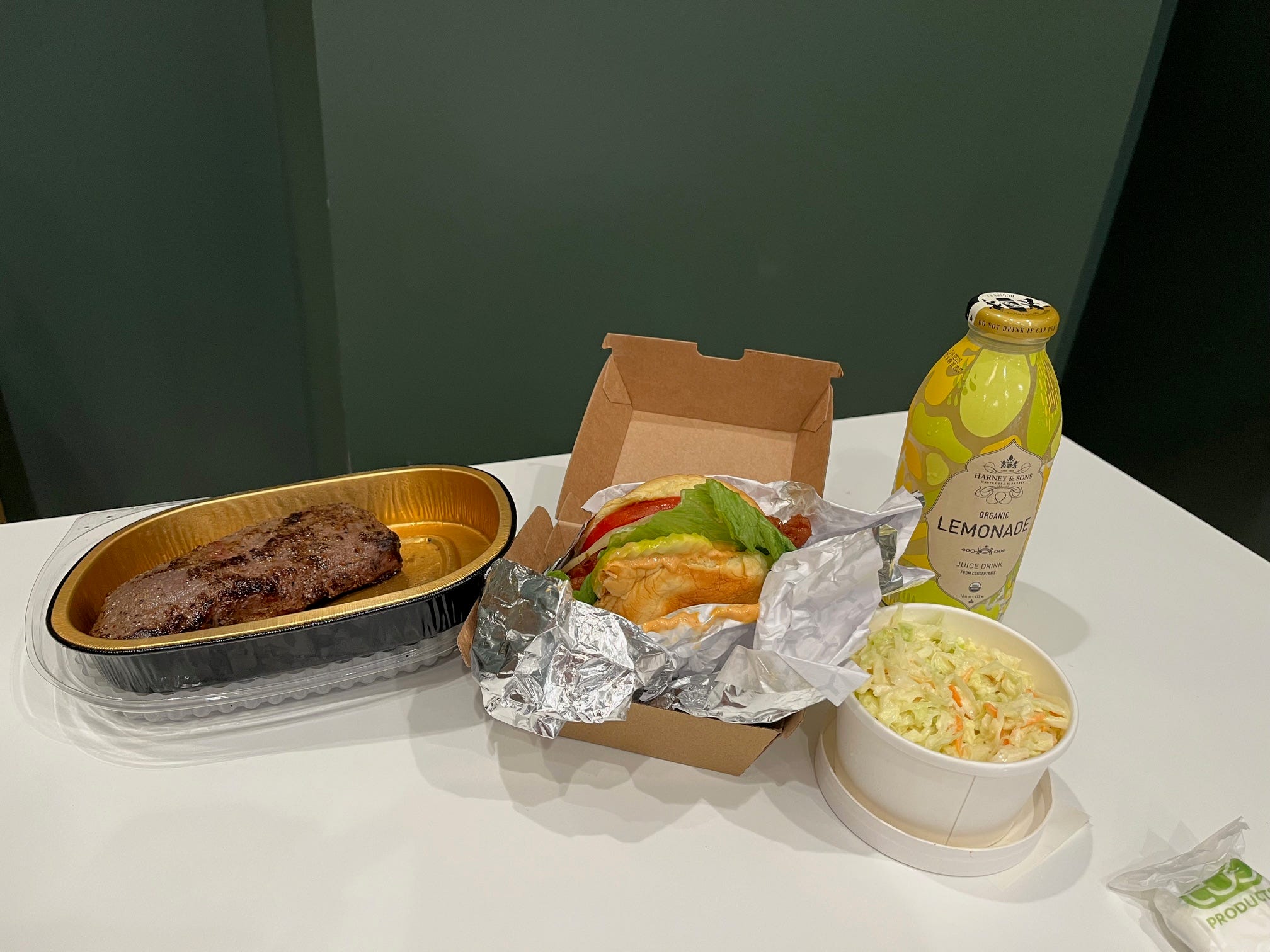A steak, fried chicken sandwich, lemonade, and coleslaw from Wonder.
